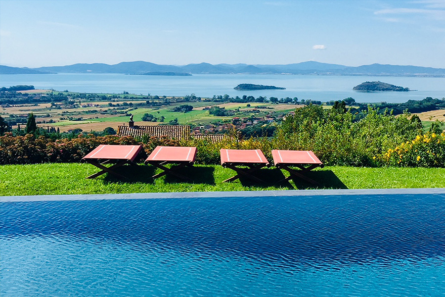 The villa pool with views over Lake Trasimeno - Umbria, Italy.